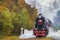 Vintage black steam locomotive train with wagons on railway.