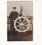 Vintage black and white photo of a man in Sailor uniform against wheel with Hamburg on 1940s.