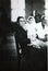 Vintage black and white photo of woman holding baby, with midwife?, 1950s European.
