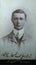 Vintage black and white photo of a young Edwardian man F. E. Whitfield, with big collar and smart suit 1900s.