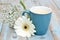 Vintage blue cup of coffee on a wooden background with white Gerbera daisy decoration