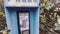 Vintage Blue outdoors public payphone booth hand grabbing receiver