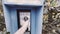 Vintage Blue outdoors public payphone booth hand picking up