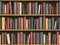 Vintage books on bookshelf. Old books tiled seamless texture background (vertically and horizontally).