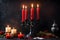 Vintage brass candelabra made of red burning candles with dripping wax on a black background. photo Playground AI