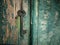 Vintage brass key on wooden wall stuck on rusty nail