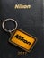 Vintage brass Nikon keychain on black diary