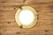 Vintage brass porthole in wooden wall