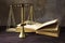 Vintage brass scales of justice and an old book on a brown woode