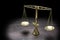 Vintage brass scales of justice in spotlight against a black bac