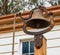 Vintage brass school bell with rope attached set atop wooden post