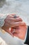 A vintage bride and groom rings on embracing hands after being married at a wedding