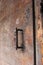 Vintage bronze rusted door handle on old wooden door with lock hole