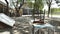 Vintage Brown Three-Legged Stool Chair Laid Upside Down on Antique Rustic Tables - Under the Tree in Abandoned Studio Garage/ Jun