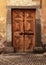 Vintage brown wood medieval door in rural stone house