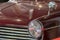 Vintage burgundy classic car. Close-up of headlamp and grill