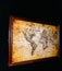 Vintage burnt world map in a frame on a black wall. interior element