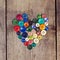 Vintage buttons in the shape of a heart on a wooden background