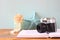 Vintage camera, book and decorations over wooden shelf