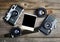 Vintage cameras around empty retro photograph on wooden background