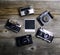 Vintage cameras around empty retro photograph on wooden background