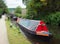 vintage canal boats passing though black pit lock in hebden bridge west yorkshire with people watching from the towpath