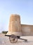 A vintage canon & the southern tower of Zubarah fort, Qatar