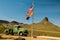 Vintage car in the arizona desert with national and state flags