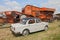 Vintage car Fiat 1100 near to an old thresher machine