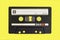 Vintage cassette tape isolated. Black audio cassette B side on yellow background.