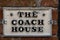 A vintage cast iron sign displaying the house name of the coach house