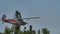 Vintage Cessna airplane in metal grey and red does a low and high speed pass