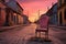 a vintage chair on a cobbled street, with a historic cityscape bathed in sunset hues