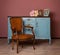 Vintage chair near blue wooden dresser