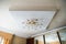 Vintage chandelier hanging under white ceiling with stucco moldings