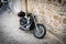 Vintage chopper bike stays parked near brick wall in Chania town on Crete island