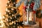 Vintage Christmas lantern with burning candle hanging on fir branch against blurred background. Space for text