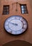 Vintage circle clock on antique building exterior. Old town street details photo. Retro painted textured weathered wall