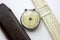 Vintage circular and flat slide rule with a case on a white background.