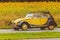 Vintage Citroen 2CV in front of a field with blooming sunflowers