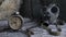 Vintage clock resting on wooden surface with military gas mask and rusty chains