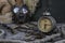 Vintage clock resting on wooden surface with military gas mask and rusty chains