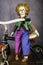 Vintage clown doll sitting on antique tricycle