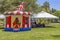 Vintage colorful small gazebo bounce house inflated next to a tent selling souvenirs for all who visit the festival