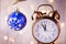 Vintage Copper Alarm Clock Showing Five Minutes to Midnight. New Year Countdown. Blue Christmas Tree Ball with Ornament Hanging