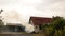 Vintage Countryside House with Burning Pile of Straw in Garden