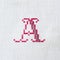 Vintage cross-stitch letter A on linen fabric