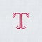 Vintage cross-stitch letter T on linen fabric