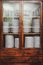 Vintage cupboard with dinnerware. old wooden kitchen cabinet with stack of white plates and cups. retro sideboard