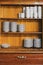 Vintage cupboard with dinnerware. old wooden kitchen cabinet with stack of white plates and cups. retro sideboard